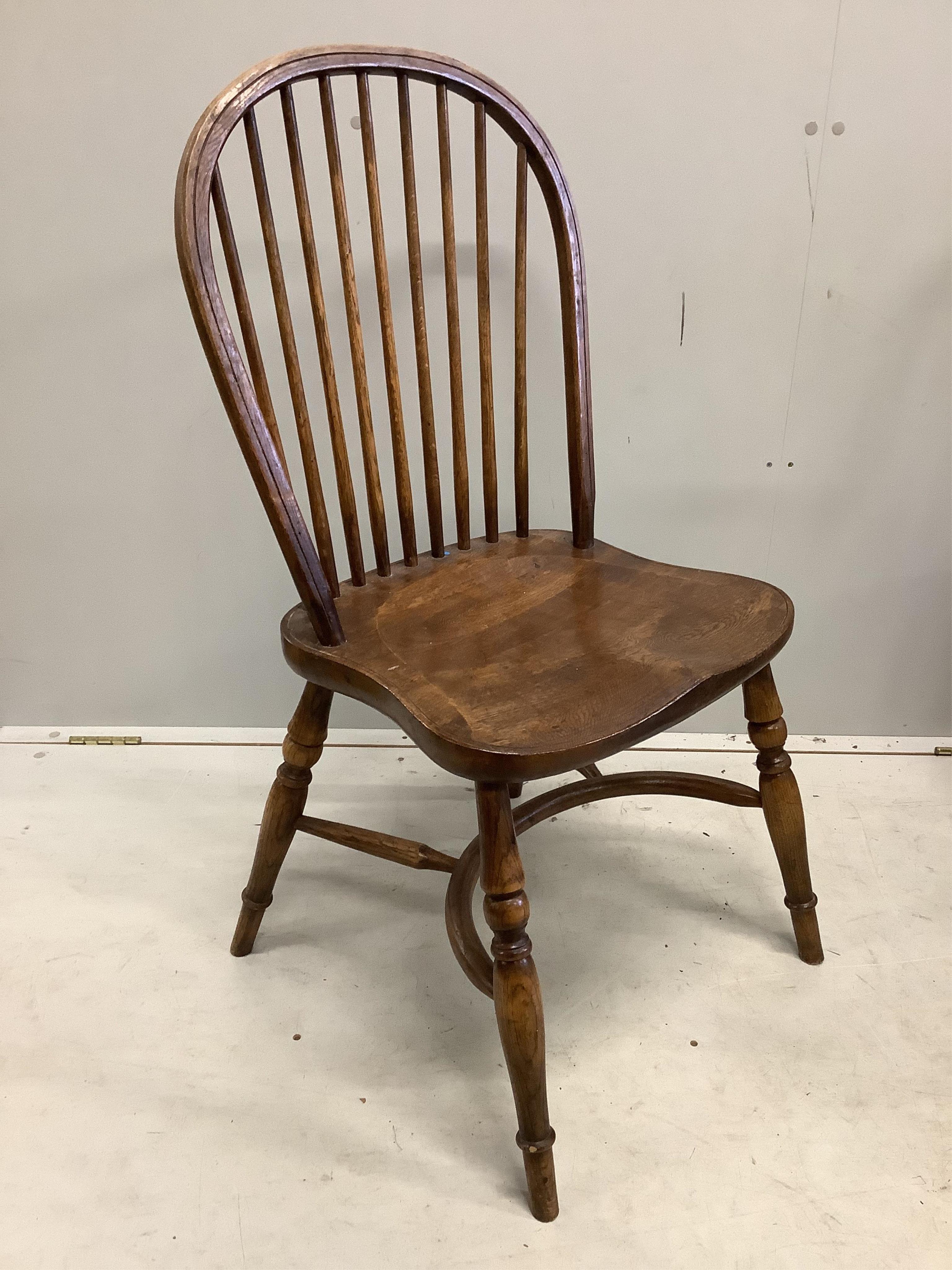 A set of six oak Windsor comb back dining chairs with crinoline stretchers, width 48cm, depth 43cm, height 94cm. Condition - fair to good